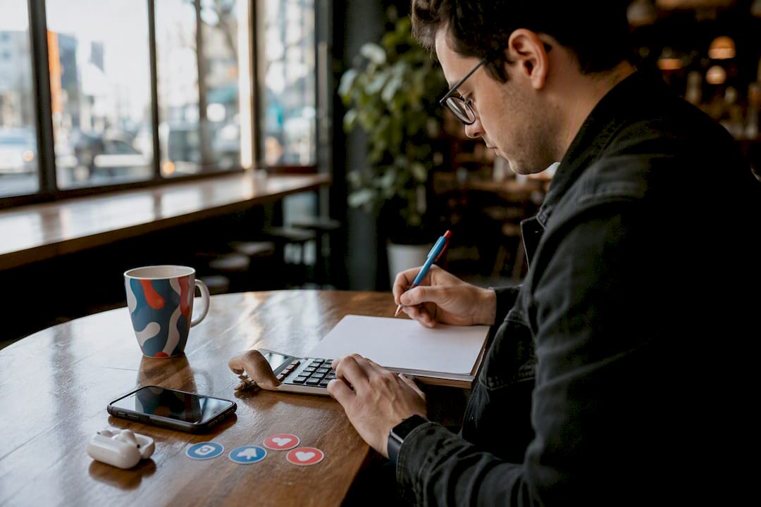Person taking notes and calculating engagement metrics